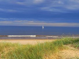 A beach with a sailboat on the water at Sea View Retreat in Bridlington