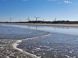 A beach with wind turbines in the background at Sea View Retreat in Bridlington
