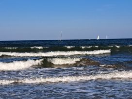 An ocean view with waves and sailboats at Sea View Retreat in Bridlington