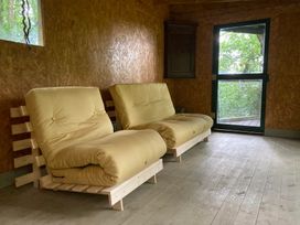 A seating area with two sofas and a window at The Tree House in the Woods Longhope