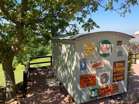 A shed with signs in an outdoor area at Cosy Shepherd’s Hut in Longhope