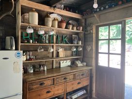 A kitchen with shelves and a refrigerator at Cosy Shepherd’s Hut in Longhope