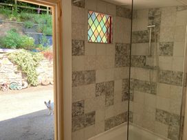 A bathroom with a shower and window at Cosy Shepherd’s Hut Longhope