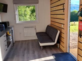 A living room with a sofa and window at The Posh Bothy 2 Roy Bridge