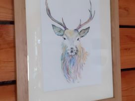 A framed colorful illustration of a deer at The Posh Bothy 2 in Roy Bridge