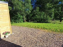 An outdoor area with a wooden wall and a planter at The Posh Bothy 2 Roy Bridge