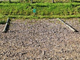 An outdoor area with gravel and wooden posts at The Posh Bothy 2 in Roy Bridge