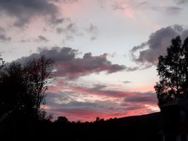 A sunset with clouds and trees at The Posh Bothy 2 Roy Bridge