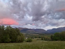 A scenic view of mountains and fields at The Posh Bothy 2 in Roy Bridge