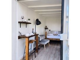 A interior view with a bed, sofa, and table at Trethowels Hidden Huts in St. Austell
