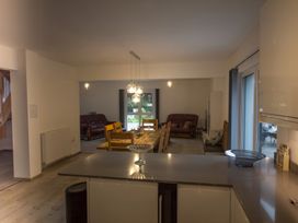 An open-plan living and dining area with a dining table and sofa at Pityme-Not Wadebridge