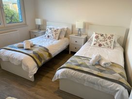 A bedroom with twin beds and a bedside table at Pityme-Not in Wadebridge