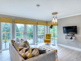 A living room with a sofa and television at Pinemarten Lodge Crianlarich