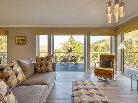 A living room with a sofa and a table at Pinemarten Lodge in Crianlarich