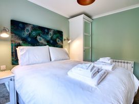 A bedroom with a bed and towels at Pinemarten Lodge in Crianlarich