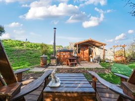 A wooden table and chairs with a hot tub at Cosy Escape in Minster On Sea