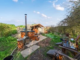 A garden with a wooden hot tub and seating area at Cosy Escape in Minster On Sea