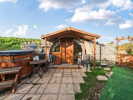 An outdoor area with a hot tub and wooden door at Cosy Escape in Minster On Sea
