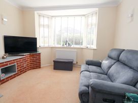 A living room with a television and sofa at 15 Coombe Avenue