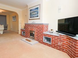A living room featuring a fireplace and television at 15 Coombe Avenue