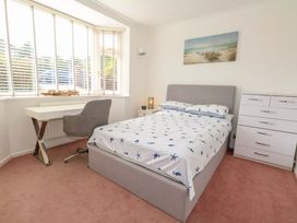 A bedroom with a bed, desk, and wardrobe at 15 Coombe Avenue