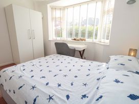 A bedroom with a bed, wardrobe, desk, and chair at 15 Coombe Avenue 