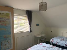 A bedroom with two beds and a table at Tudor Rose in Weymouth