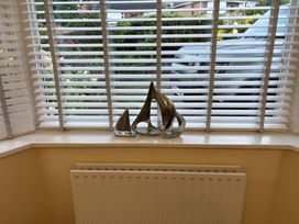 A living room with a decorative item on the window sill at Tudor Rose Weymouth