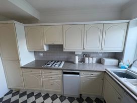 A kitchen with cabinets and a gas stove at Tudor Rose in Weymouth