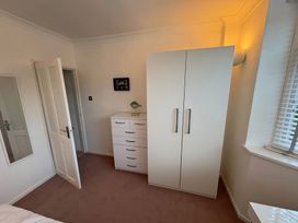 A bedroom with a wardrobe and chest of drawers at Tudor Rose in Weymouth