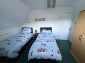 A bedroom with two single beds and a wardrobe at Tudor Rose in Weymouth