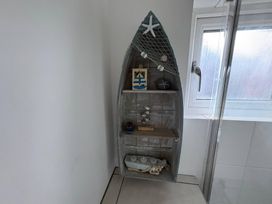 A shelf with decorative items in a bathroom at Tudor Rose in Weymouth