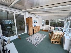 A conservatory with seating and a sideboard at Tudor Rose in Weymouth