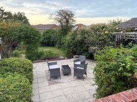A garden with chairs and a table at Tudor Rose in Weymouth