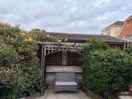 A garden with a bench and flowers at Tudor Rose in Weymouth