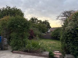 A garden with trees and plants at Tudor Rose in Weymouth