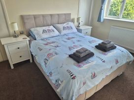 A bedroom with a bed and nightstand at Tudor Rose in Weymouth