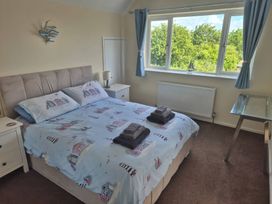 A bedroom with a bed and window at Tudor Rose in Weymouth