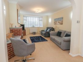 A living room with an armchair and sofa at Tudor Rose in Weymouth