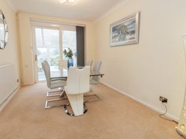 A dining room with a table and chairs at Tudor Rose in Weymouth