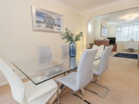 A dining room with a glass table and chairs at Tudor Rose in Weymouth
