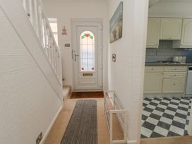 A hallway with a staircase and door at Tudor Rose in Weymouth