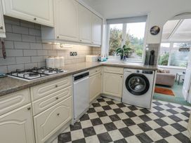 A kitchen with a gas stove, dishwasher, and washing machine at Tudor Rose in Weymouth