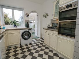 A kitchen featuring a washing machine and oven at Tudor Rose in Weymouth