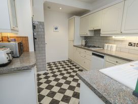 A kitchen with various appliances and cabinets at Tudor Rose in Weymouth