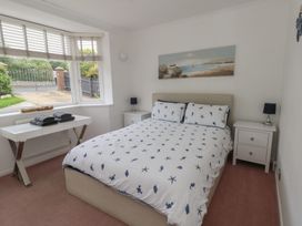 A bedroom with a bed and bedside tables at Tudor Rose in Weymouth