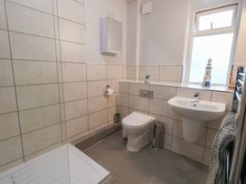 A bathroom with a sink, toilet, and shower base at Tudor Rose in Weymouth