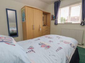 A bedroom with a bed and wardrobe at Tudor Rose in Weymouth