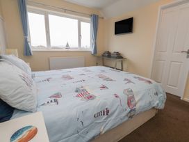 A bedroom with a bed and TV at Tudor Rose in Weymouth