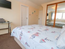 A bedroom with a bed and mirror at Tudor Rose in Weymouth